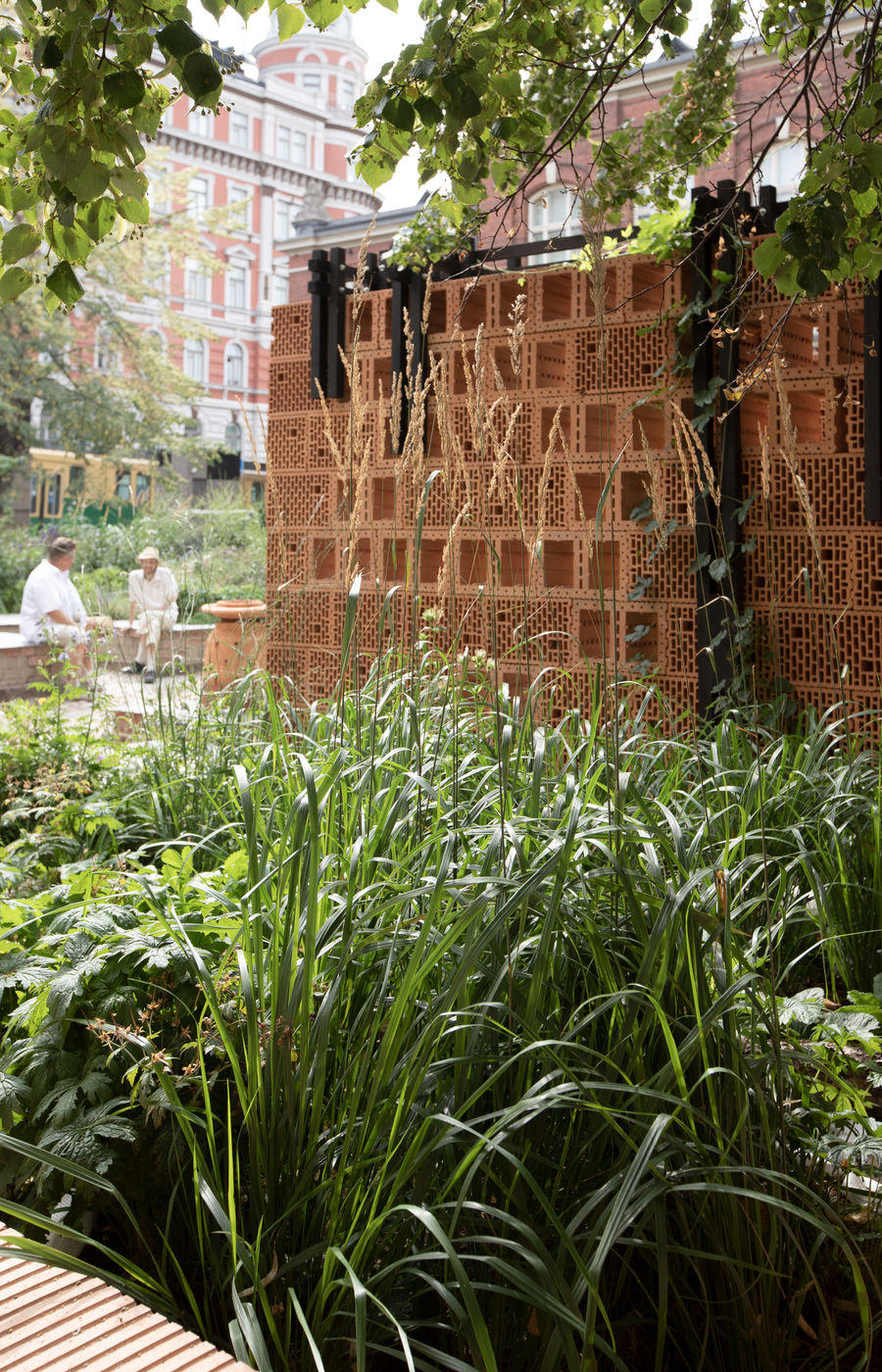 Clay brick building in the middle of growing plants in an urban environment.