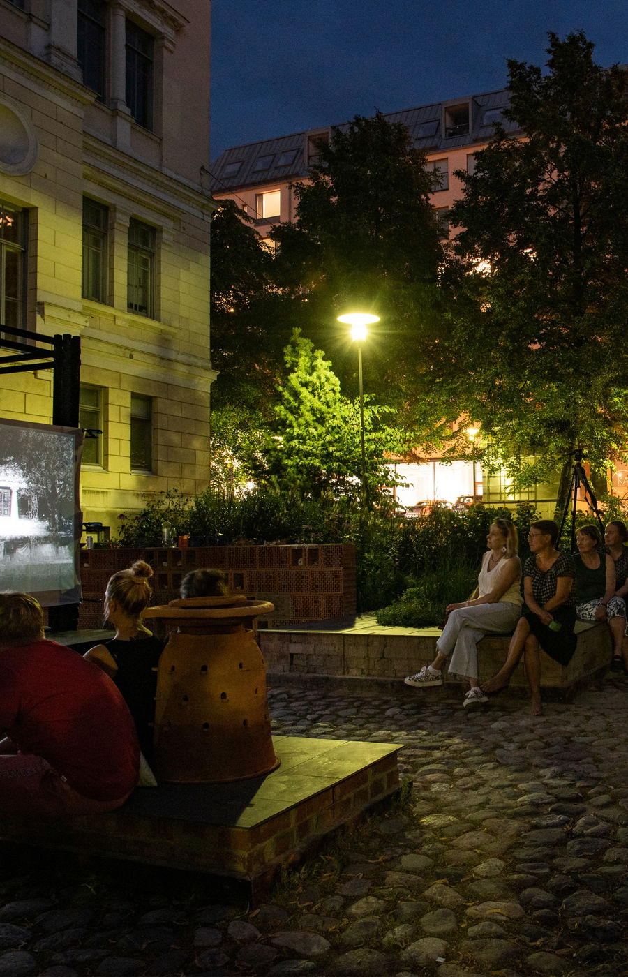 People watching movie outdoors in Alusta at night.