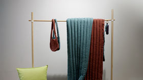 Fluff Stuff filled products - a bag and blankets - hanging on a coat rack.