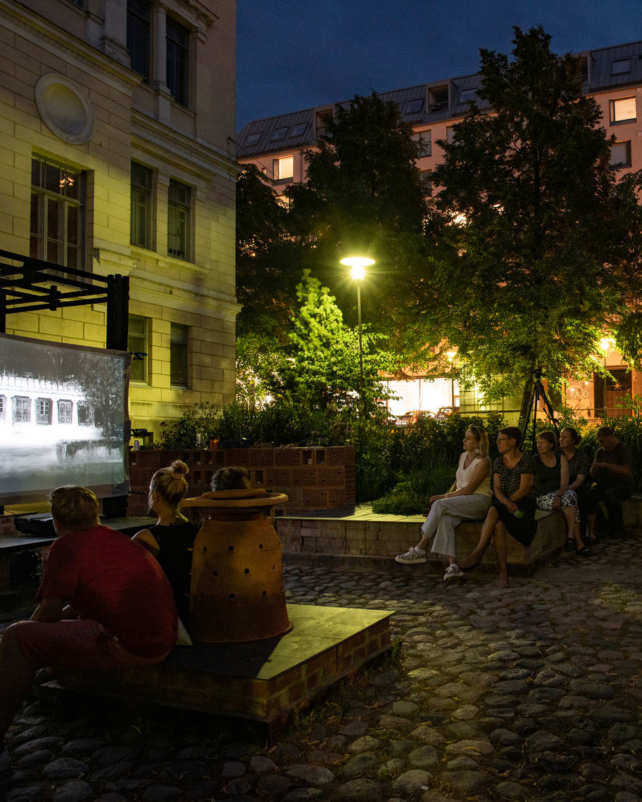 People watching movie outdoors in Alusta at night.