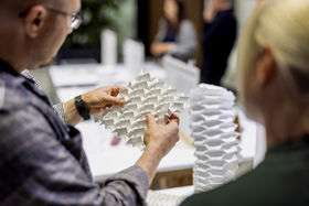 People touching and exploring the origami-like structures in the exhibition.